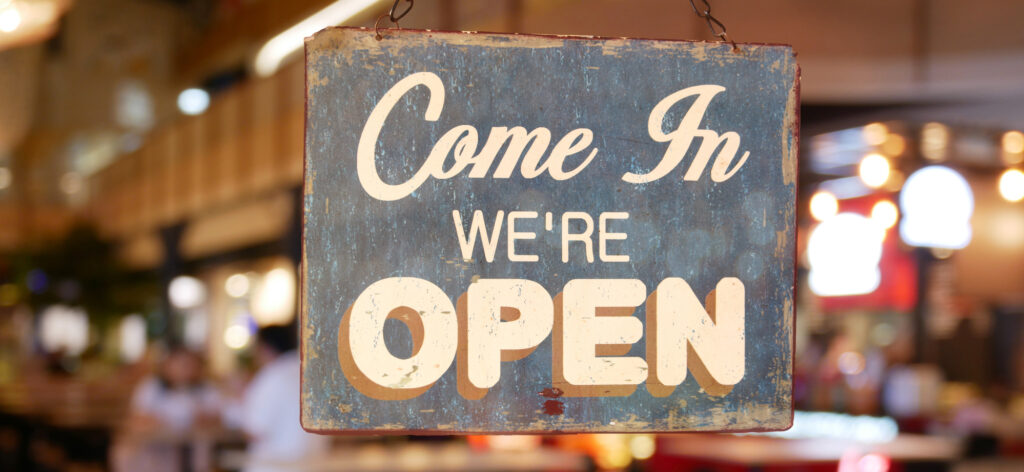 A welcome sign on the door of a restaurant